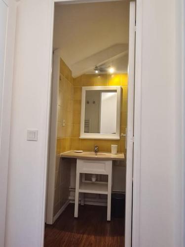 une salle de bain avec un lavabo et un miroir dans l'établissement Location Maison Meublée Marciac, à Marciac