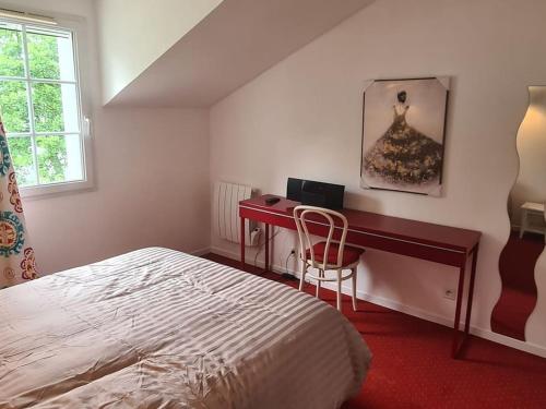 Un dormitorio con una cama y un escritorio con una computadora. en Location Maison Meublée Marciac, en Marciac