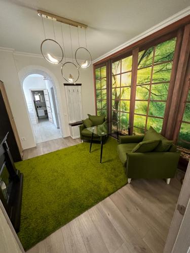 a living room with green chairs and a green rug at Emerald Apartament in Chernivtsi