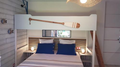a bedroom with a white bed with blue pillows at Chez Florence et Bruno in Saint-Cyr-sur-Mer