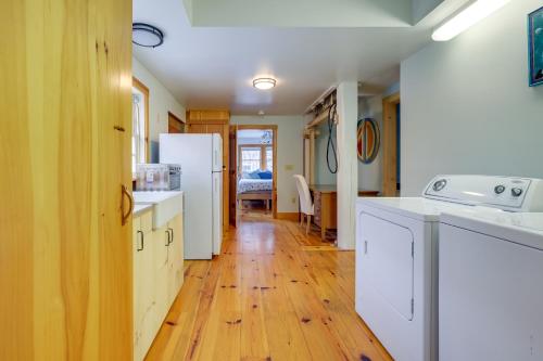 cocina con electrodomésticos blancos y suelo de madera en Unique Cape Cod Vacation Rental with Yard and Fire Pit, en Brewster