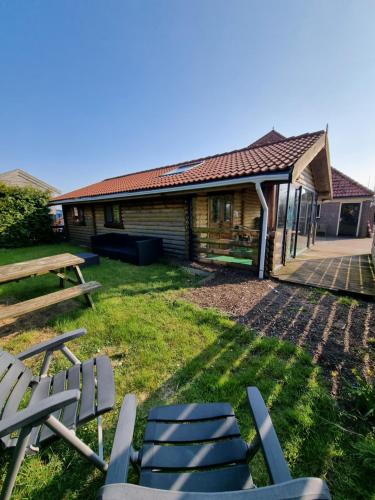 a group of chairs in front of a cabin at Finse Woning op Camping De Tulpenweide in Breezand
