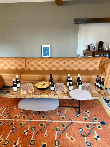 a living room with a couch and a table with bottles at Domaine Les Hauts Prés in Villaines-les-Prévôtes