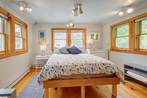 ein Schlafzimmer mit einem Bett und zwei Fenstern in der Unterkunft Unique Cape Cod Vacation Rental with Yard and Fire Pit in Brewster