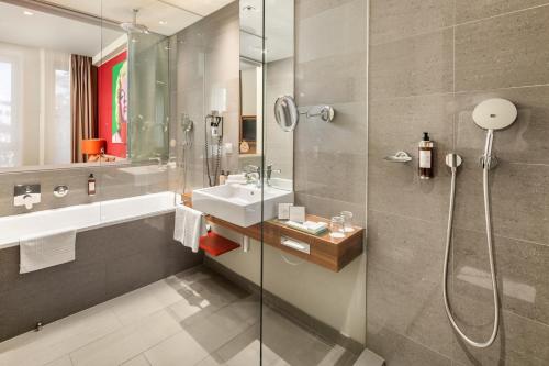 een badkamer met een douche en een wastafel bij Clarion Congress Hotel Bratislava in Bratislava
