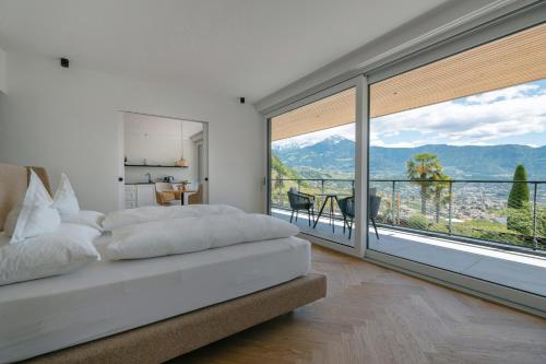 a bedroom with a bed and a large window at Schloss Plars wine & suites in Lagundo