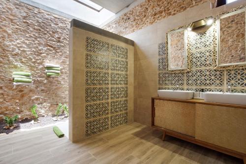 a bathroom with two sinks and a stone wall at Casa Rural Berrenda in Tiscamanita