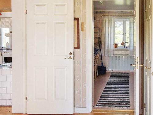 a hallway with a white door and a kitchen at Holiday home LJUSDAL IV in Ljusdal