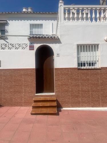 a building with a door and stairs in front of it at Malaga Chalet en Guadalmar in Málaga