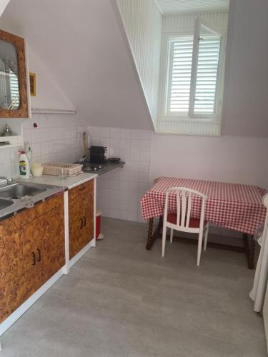 eine Küche mit einem Tisch und einem roten und weißen Tischtuch in der Unterkunft Nyugalom Szigete in Balatonszemes