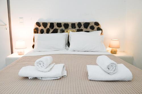 1 dormitorio con 1 cama con toallas en Villa Maina en Kamari