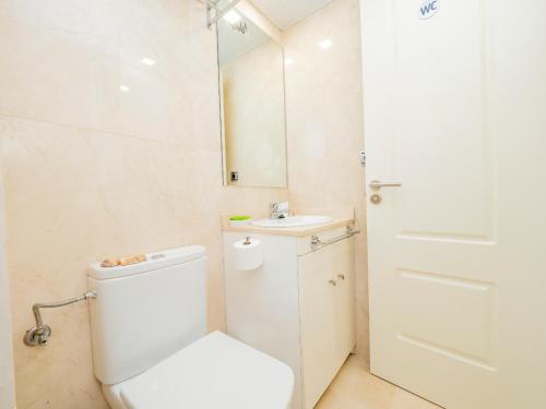 Un baño con inodoro, lavabo y espejo. en FUNNY FRIENDLY FISH HOLIDAY APARTMENTS, en Benalmádena