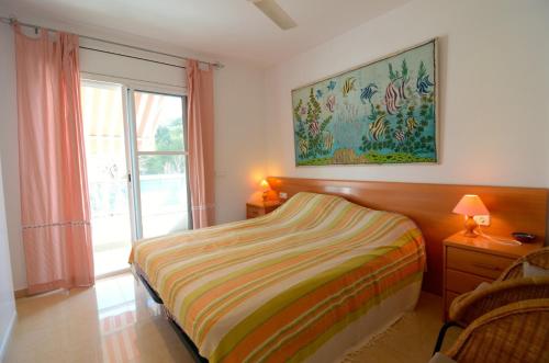 1 dormitorio con 1 cama y una pintura en la pared en Brises del Mar 3-3, en L'Estartit