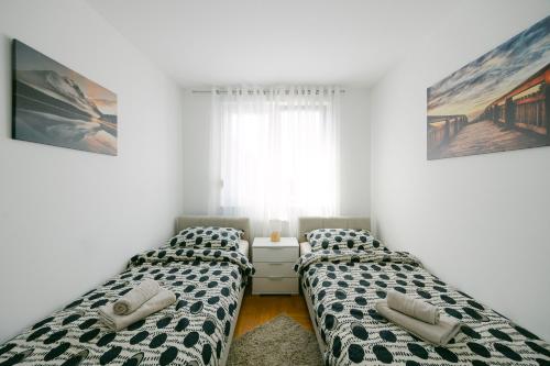 duas camas num quarto ao lado de uma janela em Ladenta apartman*** em Zagreb