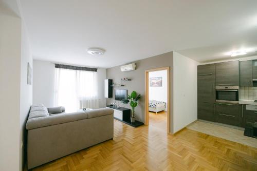 uma sala de estar com um sofá e uma cozinha em Ladenta apartman*** em Zagreb