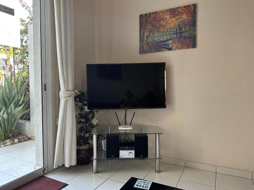 a flat screen tv sitting on a wall next to a table at Town House, Ilios II, Kato Paphos in Paphos City