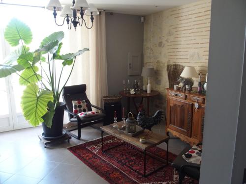a living room with a table and a plant at les tamaris in Castelnau-sur-Gupie