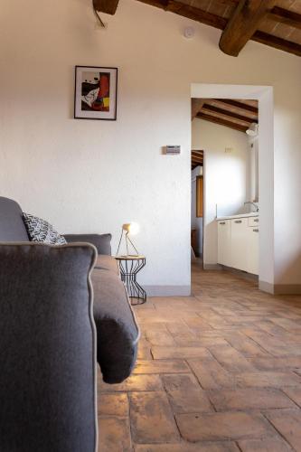 a living room with a couch and a kitchen at Rustic House, con patio e giardino, Assisi centro in Assisi
