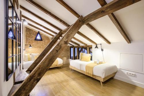 1 dormitorio con 2 camas y pared de ladrillo en Charming Madrid Serrano, en Madrid