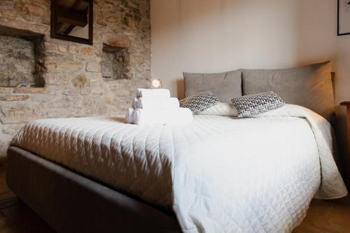 a large bed in a room with a stone wall at Rustic House, con patio e giardino, Assisi centro in Assisi