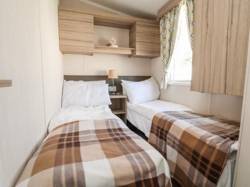 two beds in a small room with a window at ABCVan in Abergele