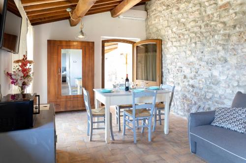 Rustic House, con patio e giardino, Assisi centro في أسيسي: غرفة طعام مع طاولة بيضاء وكراسي