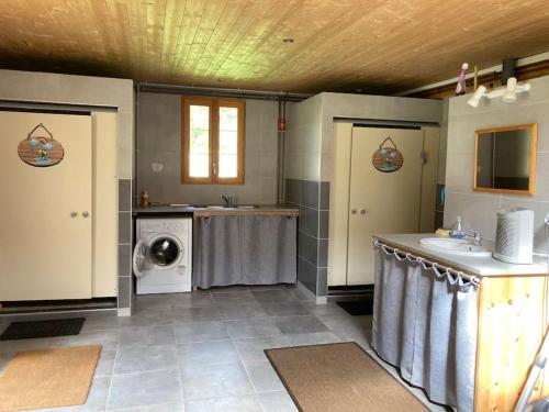 a bathroom with a sink and a washing machine at Charmant petit dortoir 3 places in Chazelles