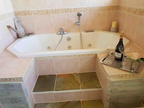 a bathroom with a tub with a bottle of wine at The Fold - 5 mins to Lytham St Annes - Ribby Hall Village 