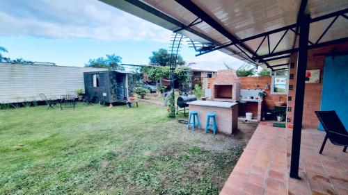 a backyard with an outdoor kitchen and a grill at Quinta Coki in Pirayú