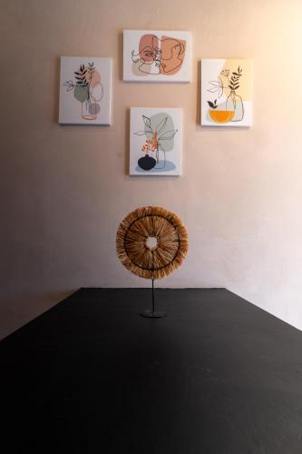 a table with a fan in front of a wall with paintings at MORF suites in Casale Marittimo