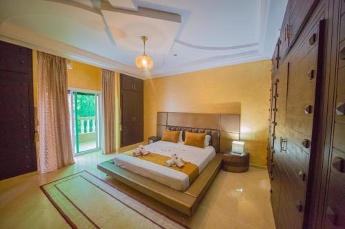 a bedroom with a bed and a large window at Ferme Prestige in Moulay Yacoub