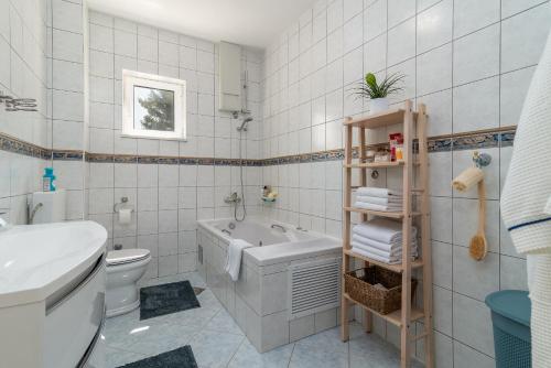 a bathroom with a tub and a toilet and a sink at Beachfront Apartment with parking in Slatine