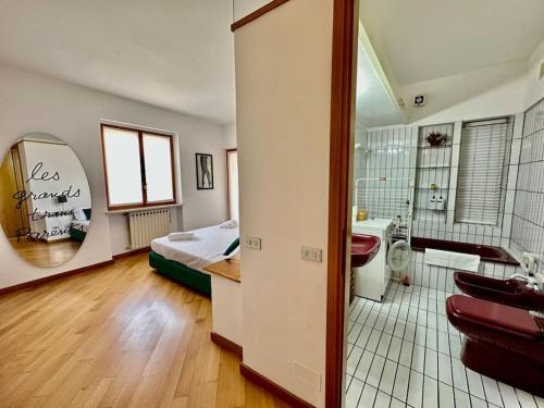 Habitación con 1 dormitorio con 1 cama y baño. en Fantastica terrazza con solarium e infernot by Revenue House, en Vignale