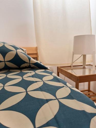 a bed with a blue and white blanket and a table at Dimora dei Pellegrini 8 in Polignano a Mare