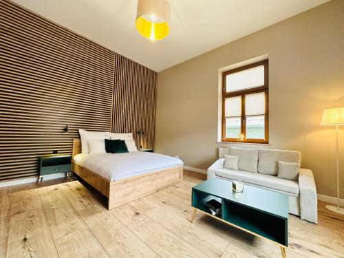sypialnia z łóżkiem, kanapą i stołem w obiekcie Apartamenty Kamienica Gwiazda w mieście Krynica Zdrój