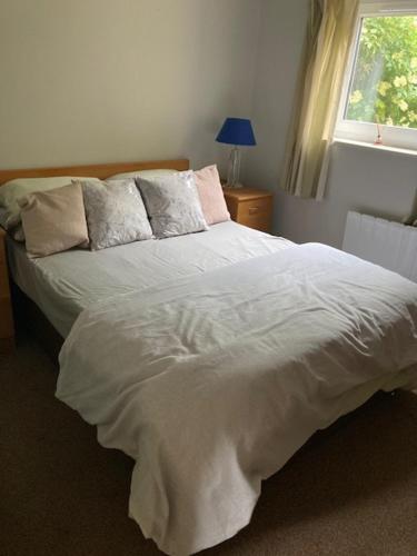 a bedroom with a white bed with a window at Seaview bungalow in Hornsea