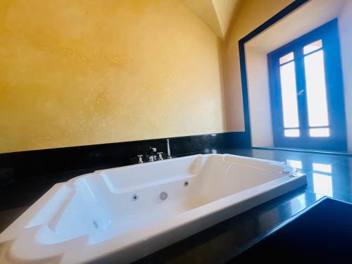 baño con una gran bañera blanca y ventana en Majestic Luxury Villa Marrakech, en Marrakech