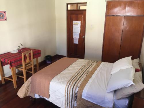 a bedroom with a bed and a desk and a table at Spanish Friends in Sucre