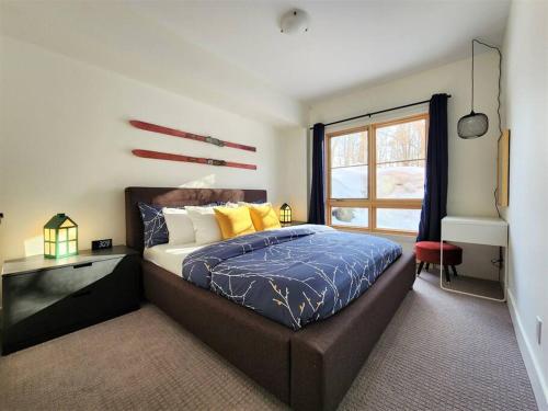 a bedroom with a large bed and a window at EDM 1500-2/Your Mountain Oasis in Mont-Tremblant