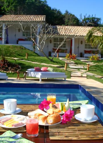 a tray of food on a table next to a swimming pool at Pousada Bucaneiro in Búzios