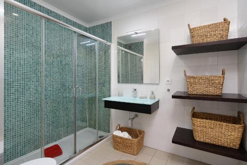 La salle de bains est pourvue d'une douche en verre et d'un lavabo. dans l'établissement Amazing Sea View w/ 2 Bdr Ideal 4 Families w/ WiFi, à Lagos