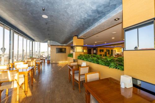 a restaurant with wooden tables and chairs and windows at Dalan Hotel -Old City istanbul in Istanbul