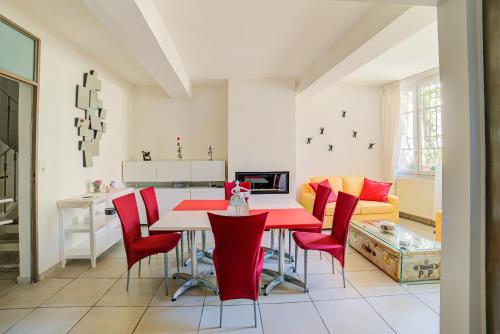 a kitchen with a red dining room table and red chairs at Le Limas in Avignon