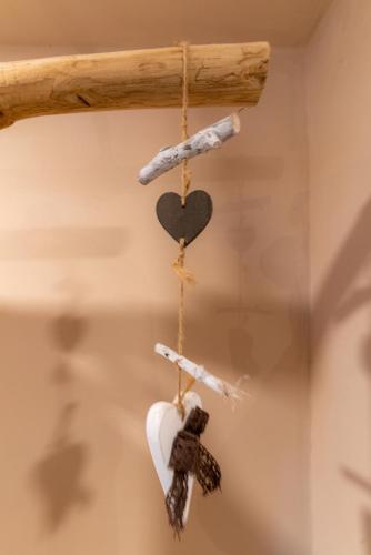 a pair of ornaments hanging from a wooden stick at MORF suites in Casale Marittimo