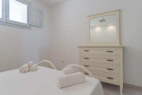 Case del Pescatore في مارينا بورتو: غرفة نوم بيضاء مع خزانة وكرسي