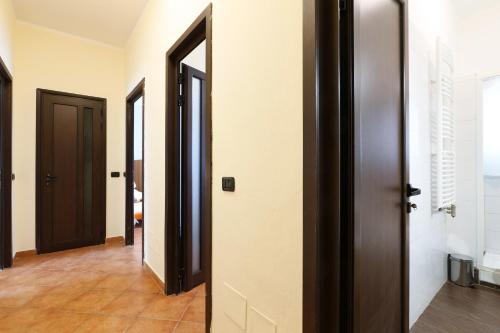 a hallway with three doors and a tile floor at PrimoPiano - Dante in Segrate