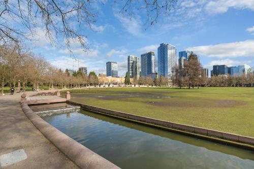 a park with a pond in front of a city at Kasa Bellevue Seattle in Bellevue