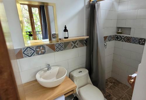 a bathroom with a sink and a toilet at Margarit Boutique Hotel in Mindo