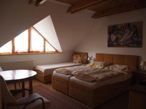a bedroom with two beds and a table and window at Privat Alenka in Liptovský Mikuláš