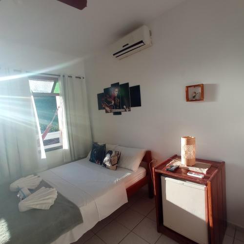 a small bedroom with a bed and a window at Pousada do Rock in Arraial d'Ajuda